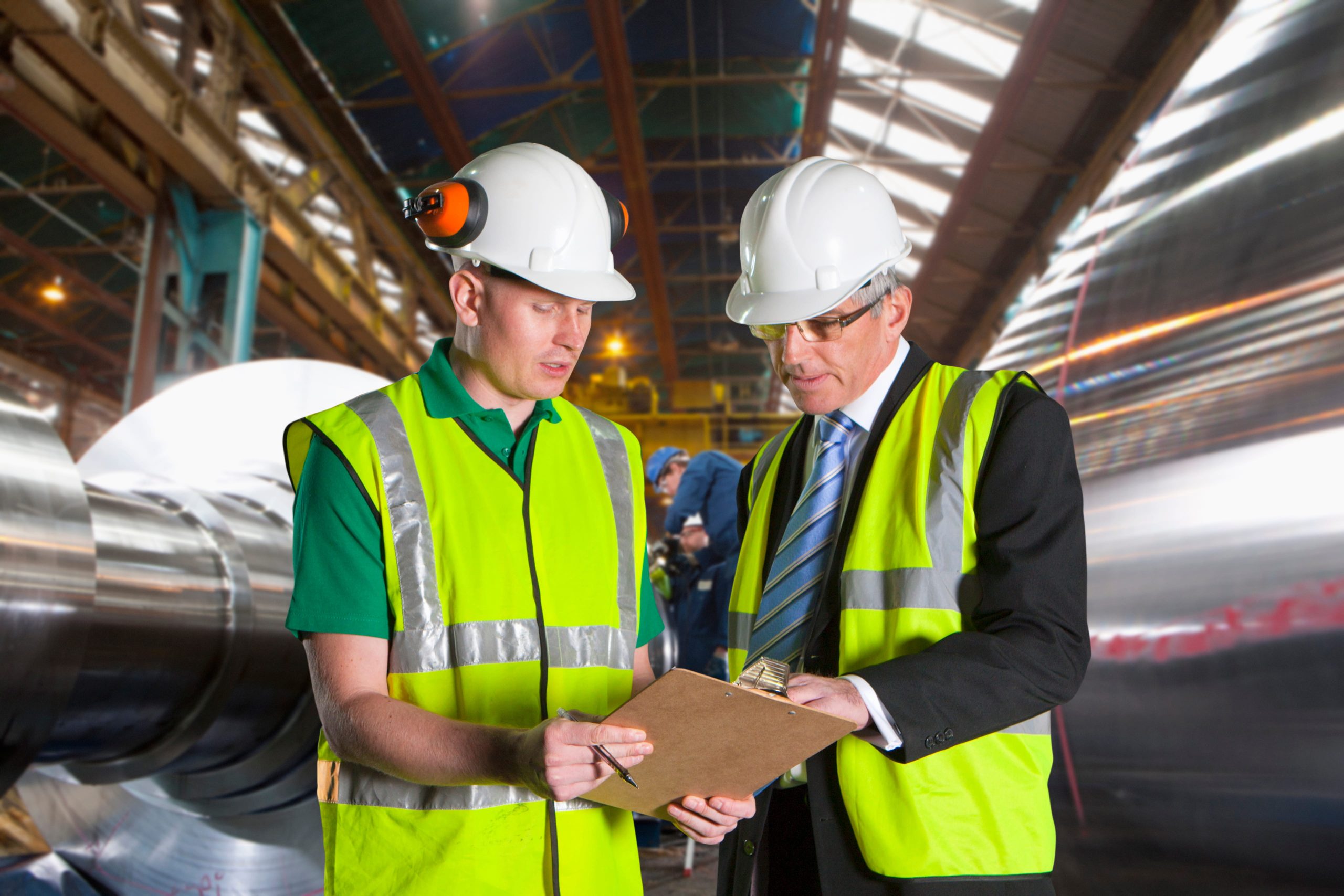 Businessman Meeting With Worker In Steel Mill to discuss gas procurement requirements